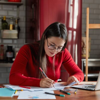 7 Smart Money Habits for a Secure Future Person calculating expenses and planning savings with coins and a notebook