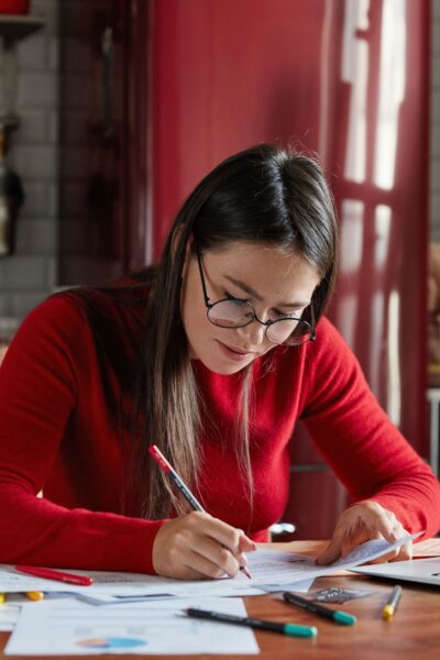 7 Smart Money Habits for a Secure Future Person calculating expenses and planning savings with coins and a notebook