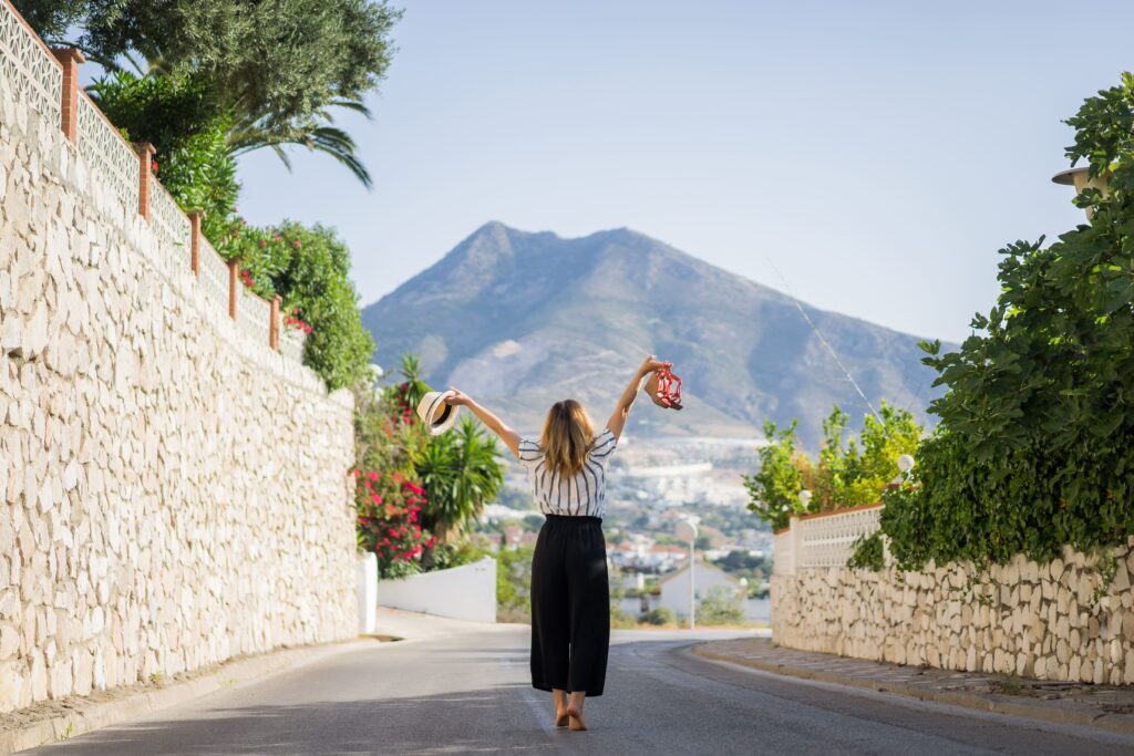 young-beautiful-woman-vacation-jumping-one-hand-sandals-second-hand-hat 