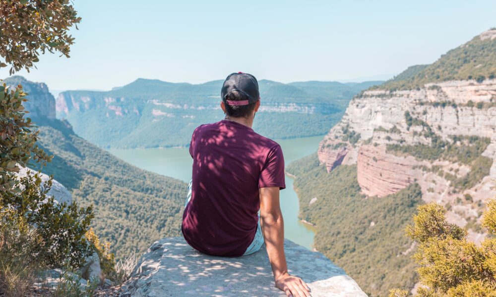 10 Affordable Travel Destinations for 2025 A traveler enjoying a scenic view of mountains on a budget trip