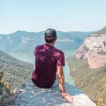 10 Affordable Travel Destinations for 2025 A traveler enjoying a scenic view of mountains on a budget trip