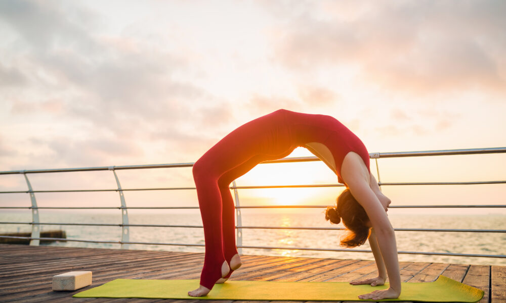 10 Morning Habits That Can Transform Your Health and Boost Your Energy A person doing yoga at sunrise as part of a healthy morning routine